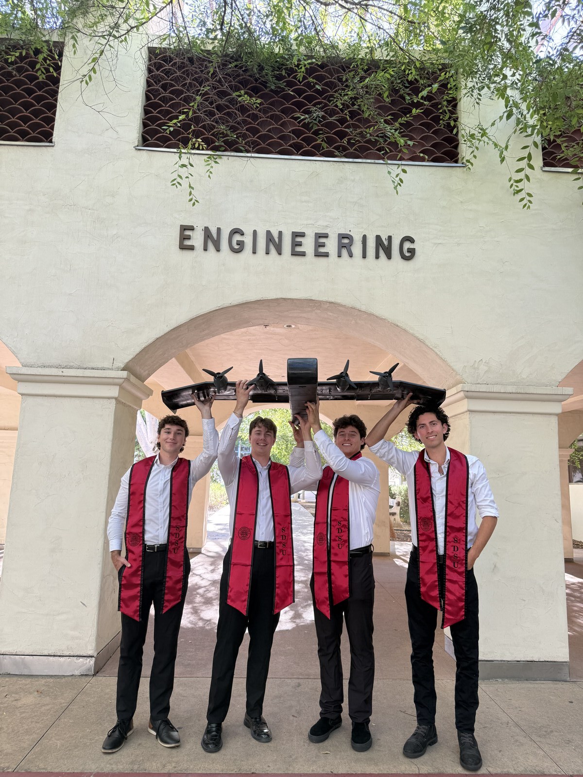 Team holding the WIG vehicle overhead under the Engineering archway.